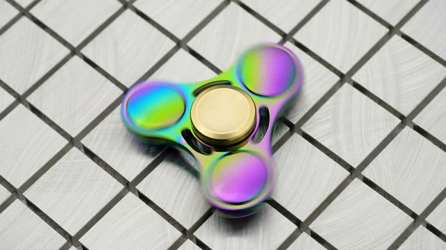 Toy fidget spiner on a  metal surface.
