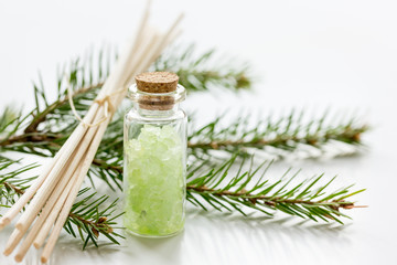 fir branches and spruce bath salt on white table background