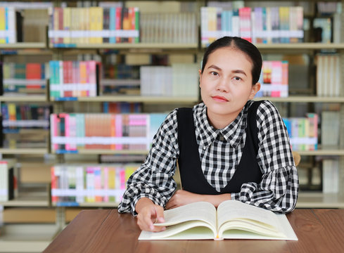 Young asian woman reading book in the library.