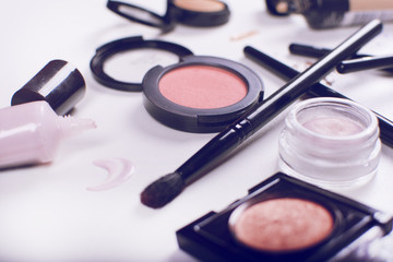 Colorful frame with various makeup products on a white background. Beauty and makeup concept.