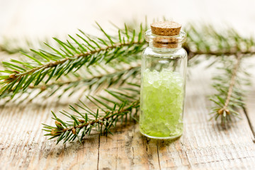 Spruce spa with organic salt in bottles on wooden table background