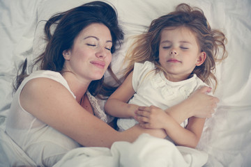 Mother and daughter in the bed together.