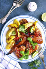 Grilled chicken wings with baked potato.Top view.