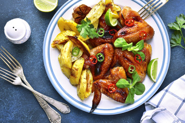 Grilled chicken wings with baked potato.Top view.