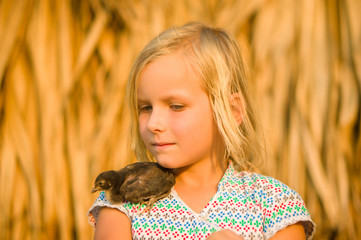 Adorable girl playing with tiny little chick on hands