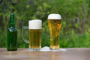  Glasses of beer and bottle on green  background