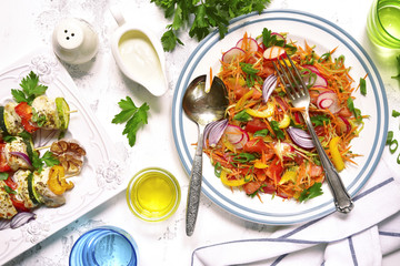Summer dinner - fresh vegetable salad and grilled chicken skewers.Top view.