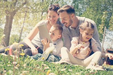 Family using tablet outdoors.