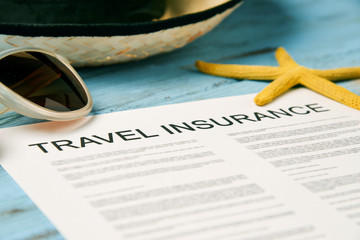 sunglasses, straw hat and travel insurance policy