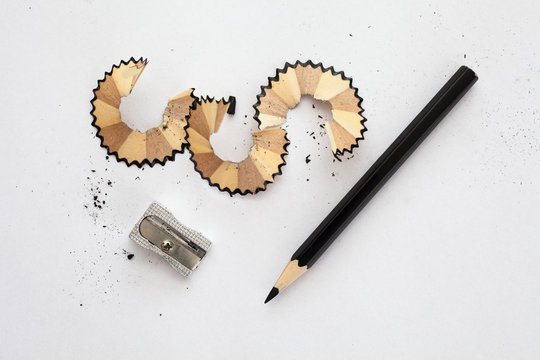 black wooden pencil, sharpener and pencil shavings