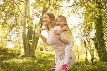 Mother and daughter outdoors in a meadow.