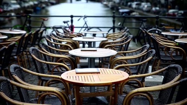Amsterdam Cafe restaurant terrace on bridge. Tables and menus. Nobody.