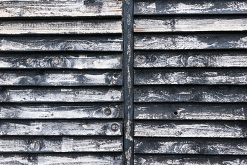Close up detail on faded and decaying wooden window shutters