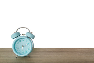 Blue classic alarm clock on vintage wooden desk on white background