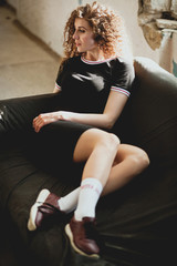 Beautiful young woman with curly hair lying on sofa