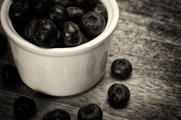 Pot of blueberries on a rustic background