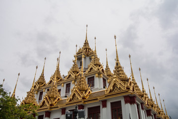Fototapeta premium Loha Prasat Wat Ratchanatdaram in Bangkok Thailand which means iron castle or monastery is composes of five towers, of which the outer, middle and the center tower contain large black iron spires. 