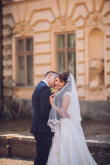 Naklejka premium beautiful couple in wedding dress outdoors near the castle