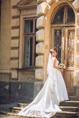 Fototapeta premium Beautiful bride near old big wooden doors