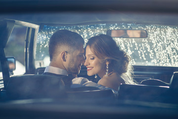 Portrait of happy newlywed couple in car on sunset after rain - Powered by Adobe