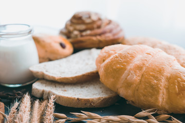 fresh bread and baked goods on wooden chopping board, rustic style