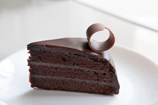 tasty dark chocolate cake on white plate. sliced delicious cocoa dessert.