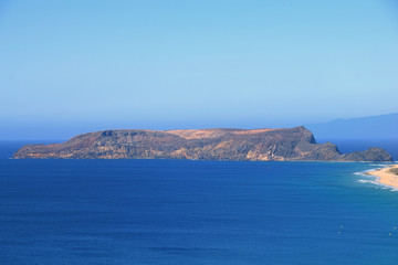 Ilheu da Cal barren uninhabitated island to the south of Ponta Da Calheta, Porto Santo with Madeira to the right on the horizon