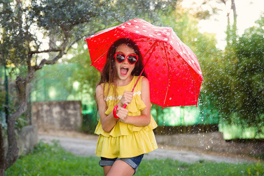 girl in water spray under umbrella