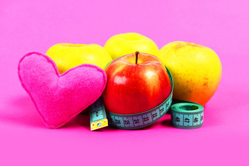 Apple fruit of red and yellow color with measuring tape