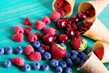 Berries poured out from cones on a gray table.