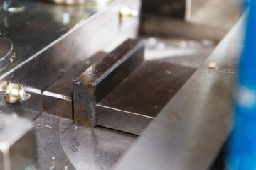The face milling tool with the raw material work piece on the CNC milling machine.The spindle with holder and tooling for face milling on CNC milling machine. Selective focus