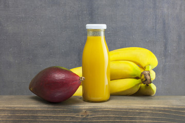 organic smoothie mango and bananas juice glass on wood .Tropical fruit concept..