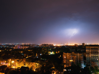 Lightning storm over city in purple light