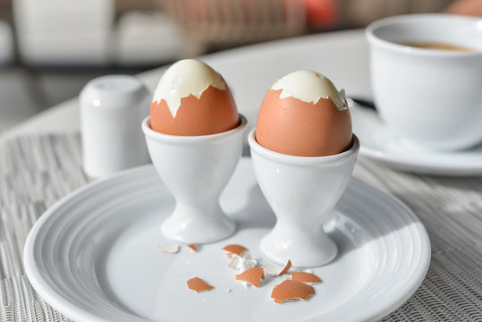 Boiled eggs in egg cup on a white plate