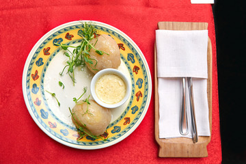 Traditional Lithuanian dishes from potatoes - zeppelins with sauce on a plate  © maksim_e