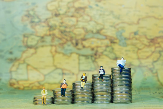 Saving money, Financial, Business Growth concept. Miniature people: Group of businessmen and businesswomen figures sitting on top of stack of coins with reading a book, waiting and talking with map