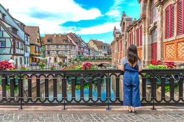 Asian girl admires the urban landscape of Colmar, France - obrazy, fototapety, plakaty