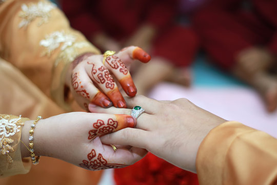 Malay Wedding Couple Putting A Gold Ring On Hand.Selective Focus And Shallow DOF.