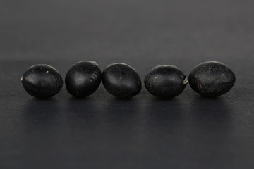 Five Black Beans on the black background.