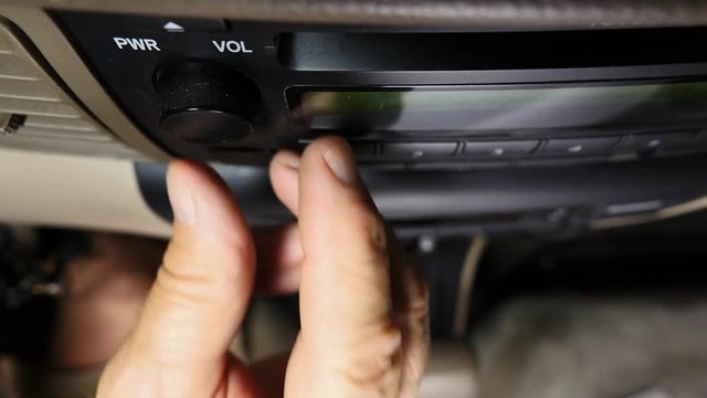 Car Driver Inserting A Music CD Into The Player