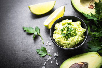 Traditional latinamerican mexican sauce guacamole on black.