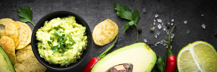 Traditional latinamerican mexican sauce guacamole on black.