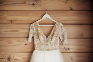 bridal dress hanging on wooden wall