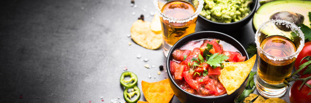 Latinamerican food party sauce guacamole, salsa, chips and tequila. Long banner format.