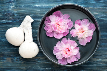 Obraz na płótnie Canvas Spa massage. Thai herbal balls and pink flowers in a bowl of water