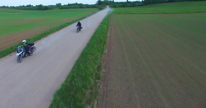 Motorcyclists touring Lithuania passes by on an enduro road bike, suited for gravel road and with pack and panniers full of supplies for traveling and camping.