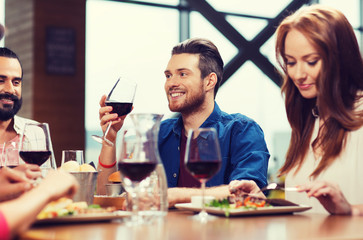 friends dining and drinking wine at restaurant