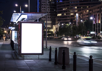Blank poster on bus stop at night
