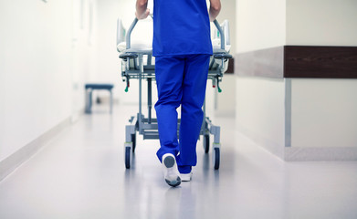 nurse carrying hospital gurney to emergency room