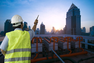 Fototapeta premium Engineer is serious action while working on the roof top of building in the city.
